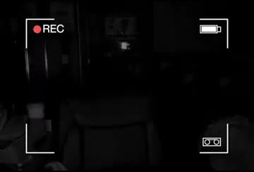 The picture after the static: dark, chairs in the foreground, same camera overlay